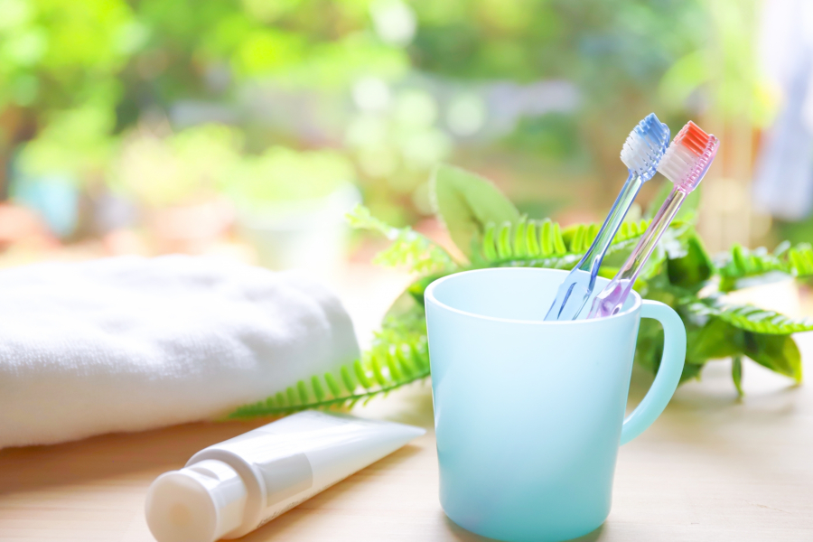 庭の見える窓辺に置かれたタオルとコップ、歯ブラシ。