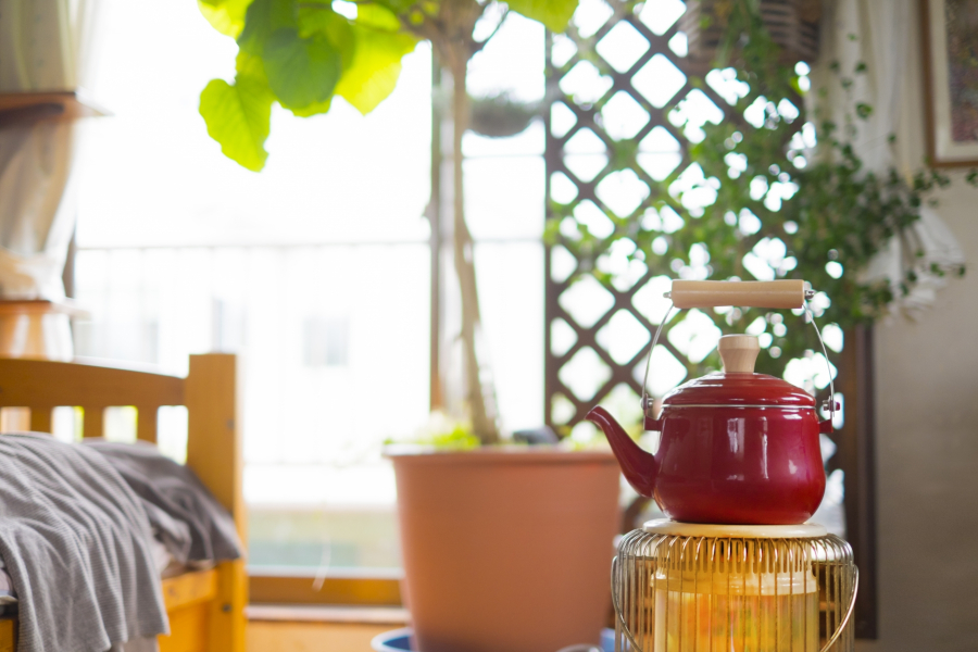 寝室に置かれただるまストーブの上の赤いやかん