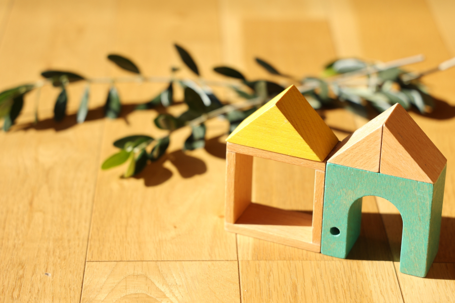 フローリングの床の上に置かれた積み木の家2つ