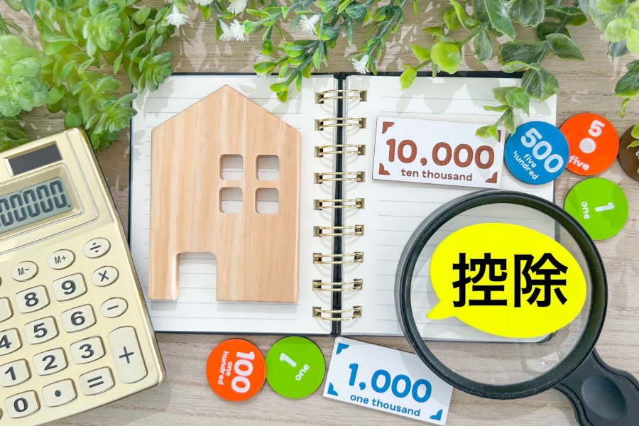 開いたノートの上に家とお金のオブジェ、控除の文字