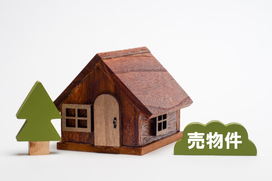 古い木の家のオブジェと「売物」の文字